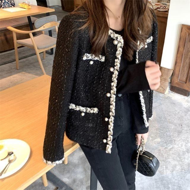 Svart elegant boucle jakke for dame med stilrene knappedetaljer. Perfekt som motejakke for vår og høst.