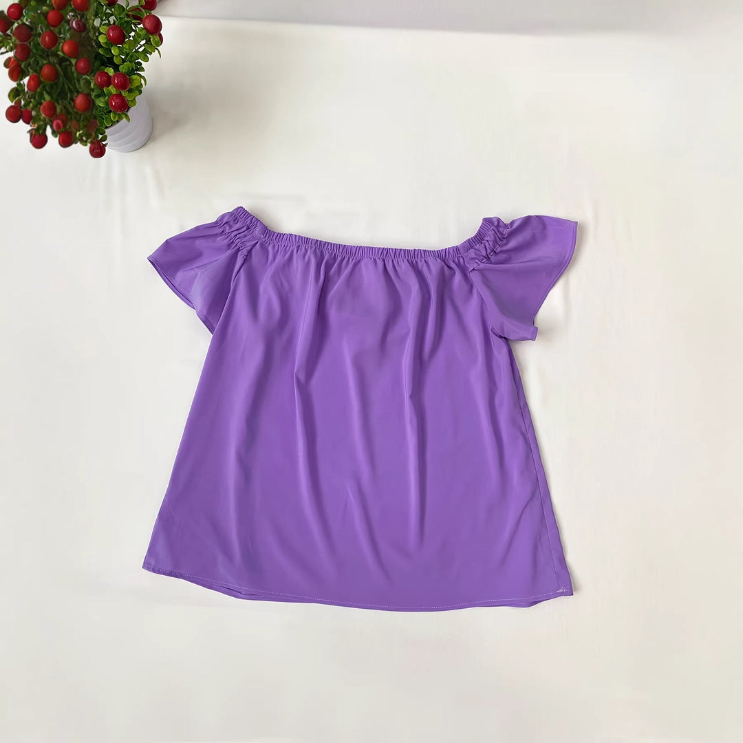 Lett og luftig lilla skulderfri bluse for damer. Volanger gir et lekent uttrykk. En must-have elegant sommertopp.
