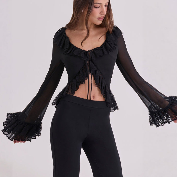 Stilfull hvit damebluse med intrikate spissdetaljer ved krage og mansjetter, perfekt for en elegant stil.