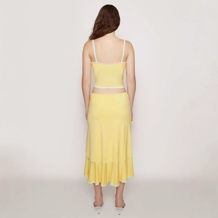 Vakkert blonder damesett med ermeløs crop-top og høy midje skjørt. Et elegant sommerlig festantrekk.