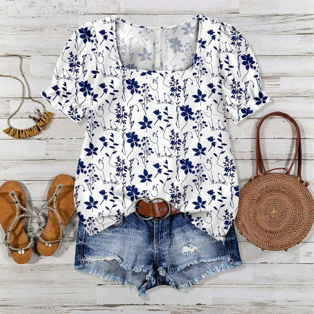 Blå kortermet damebluse med elegant blomsterprint. Perfekt sommerbluse for kvinner.