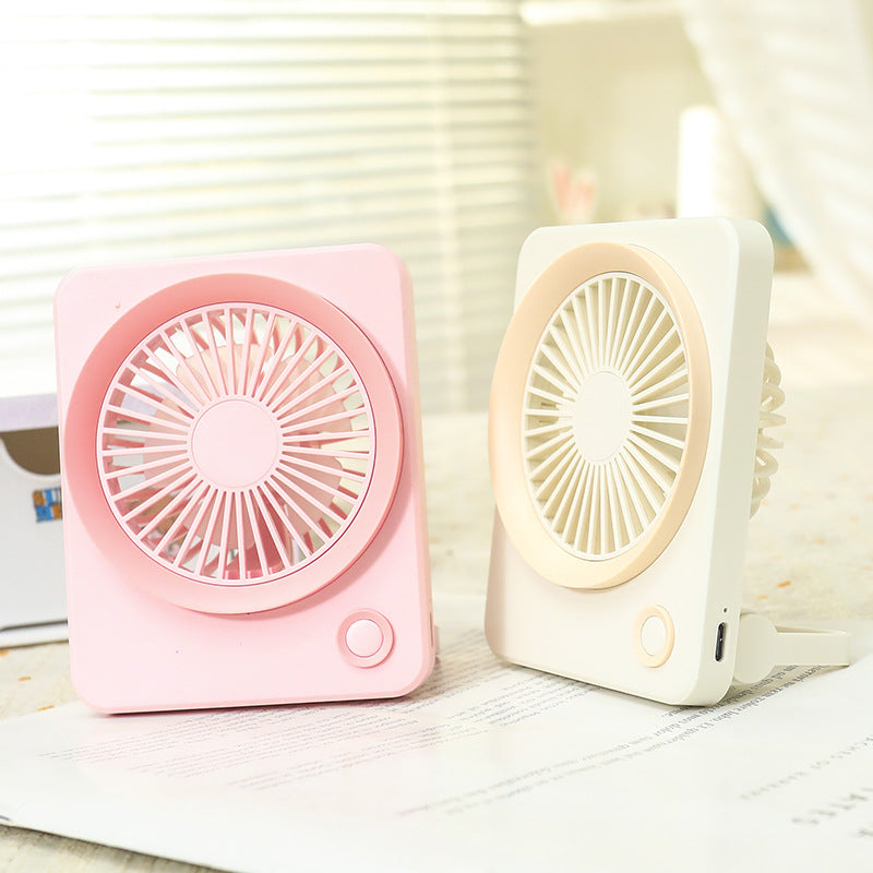 Stilren minivifte i rosa og grått, en kompakt gadget for kvinner som søker bærbar vifte og sommerfriskhet.
