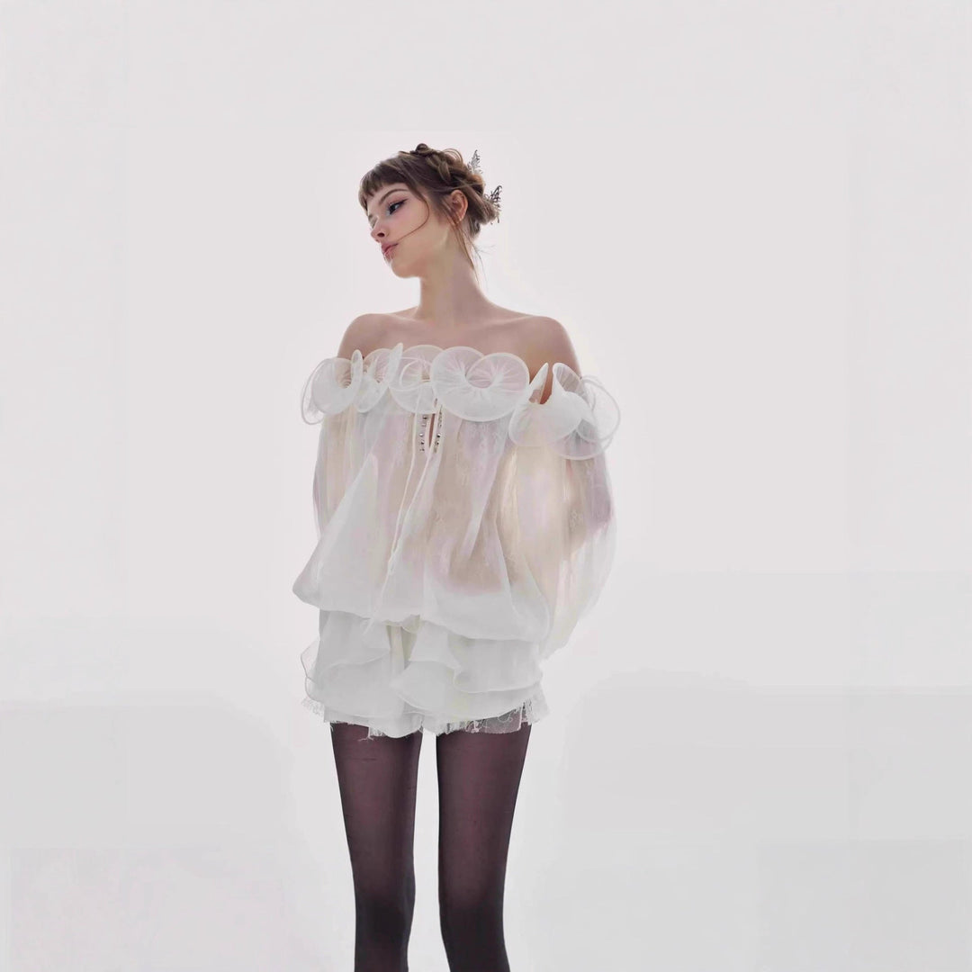 Elegant hvit damebluse med volanger og offshoulder-design, perfekt sommerbluse for fest eller hverdag.