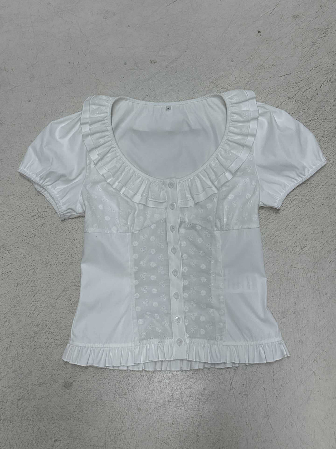 Feminin damebluse, kortermet, hvit med blomster og volanger, ideell for sommer.