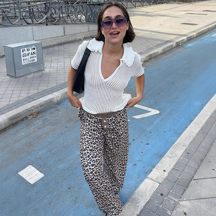Detaljert bilde av brun leopardbukser, viser stoffkvalitet og trendy mønster for damemote.