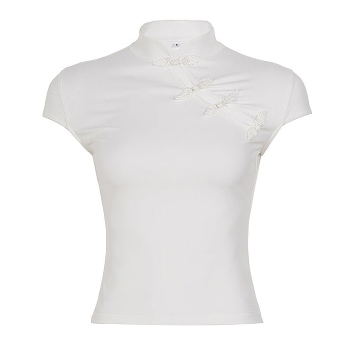 Modell iført elegant hvit kortermet topp med høy hals og delikate blonder. Allsidig for jobb eller fest.