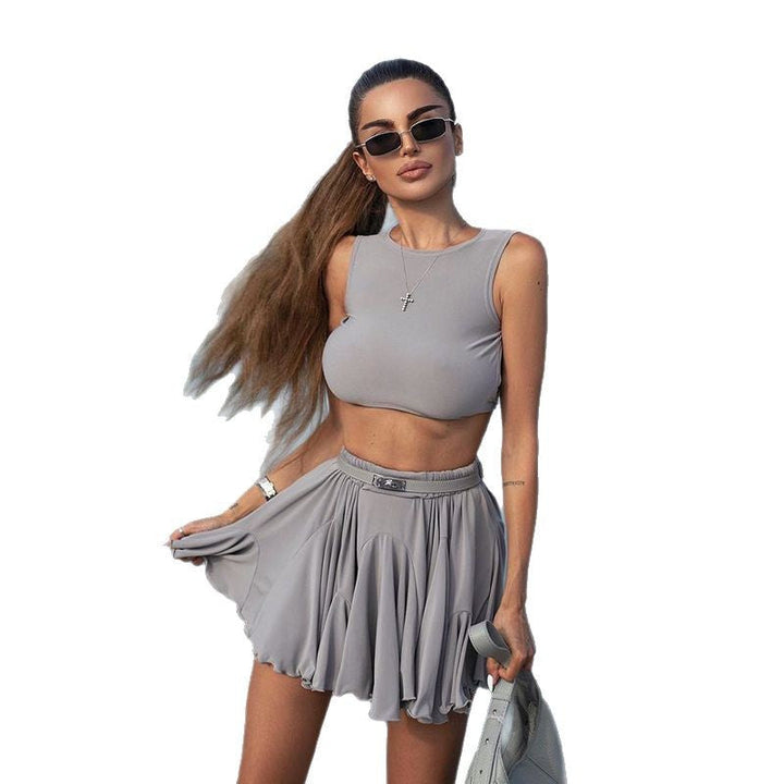 Modell iført et stilig, sporty dame sett med tettsittende crop-top og miniskjørt.