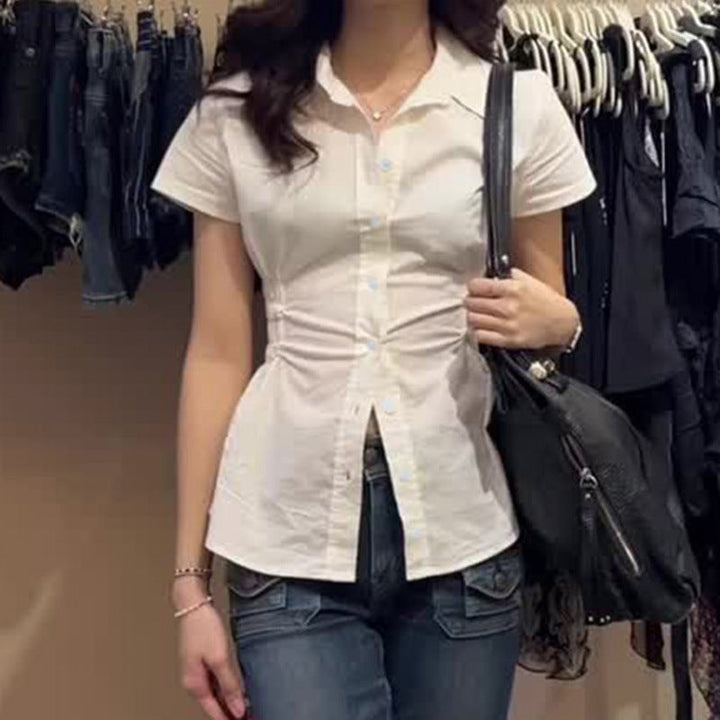 Figurnær damebluse med korte ermer, rynker og elegante knappedetaljer. Perfekt for kontor og hverdag.