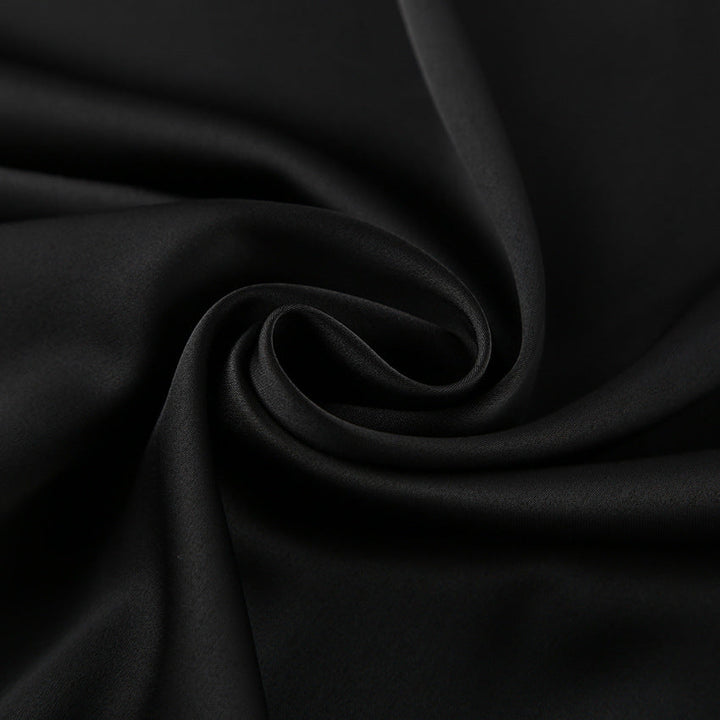 Nærbilde av elegant svart satengtopp, viser stoffets glans og tidløse design for kvinner.