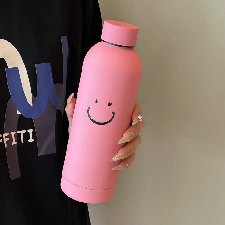 Moderne isolert drikkeflaske 500ml for kvinner, med smilende motiv. Praktisk termoflaske til hverdags.