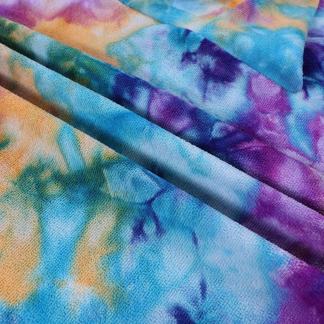 Komfortabel og allsidig dameponcho i fargerik tie-dye design med hette.
