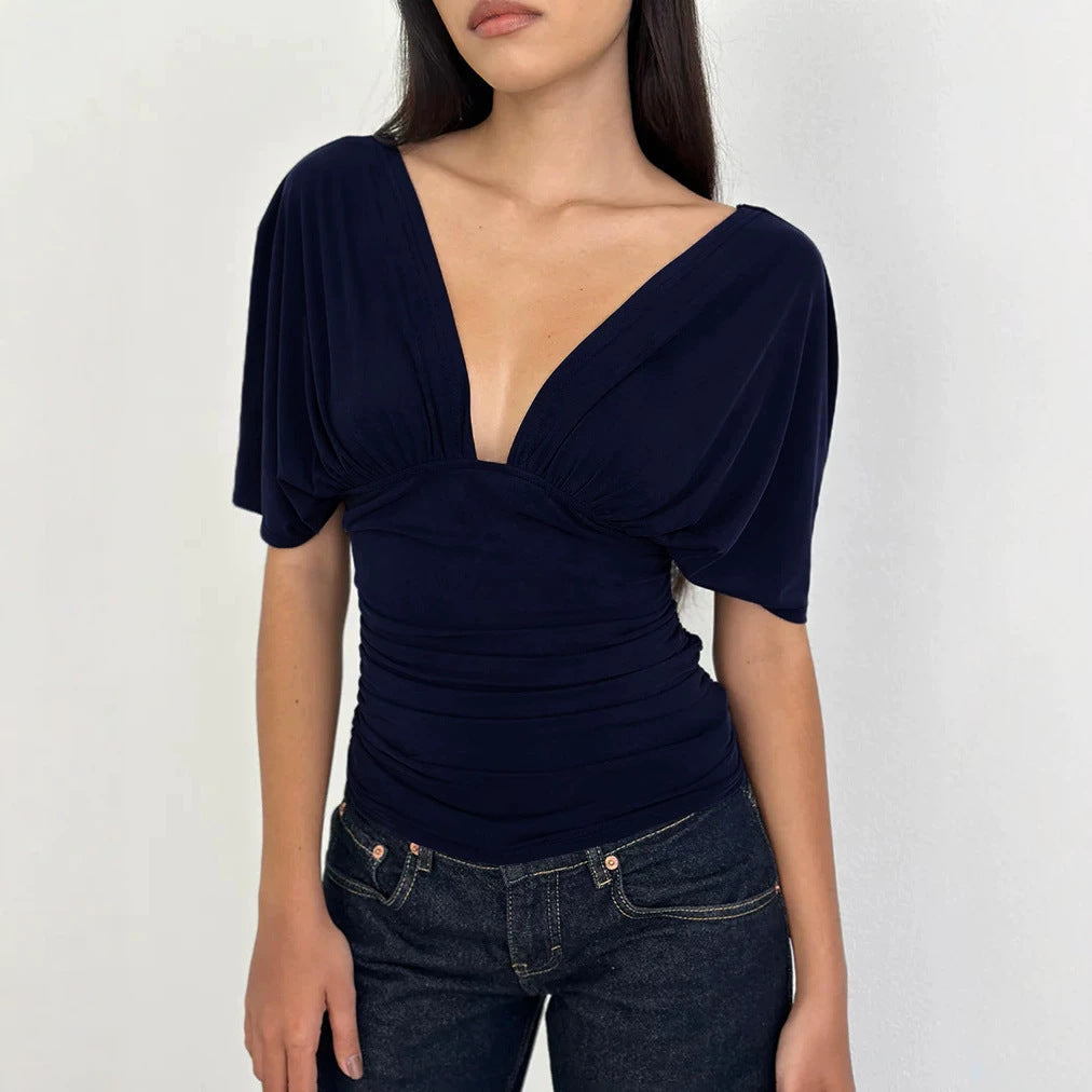 Elegant dametopp med dyp V-hals og vakker drapering, perfekt for en avslappet stil.
