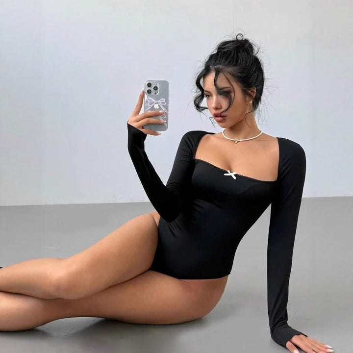 Damebodysuit med lange ermer og elegant utringning, figurnær passform. Ideell for hverdag og fest.