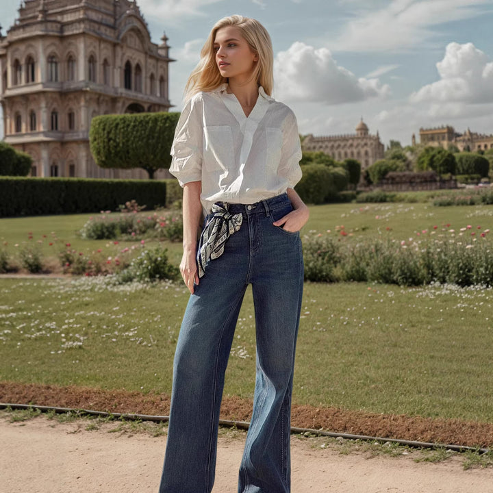 Modell iført hvit oversized skjorte/bluse for kvinner, viser løs passform og elegant stil for jobb/fritid.