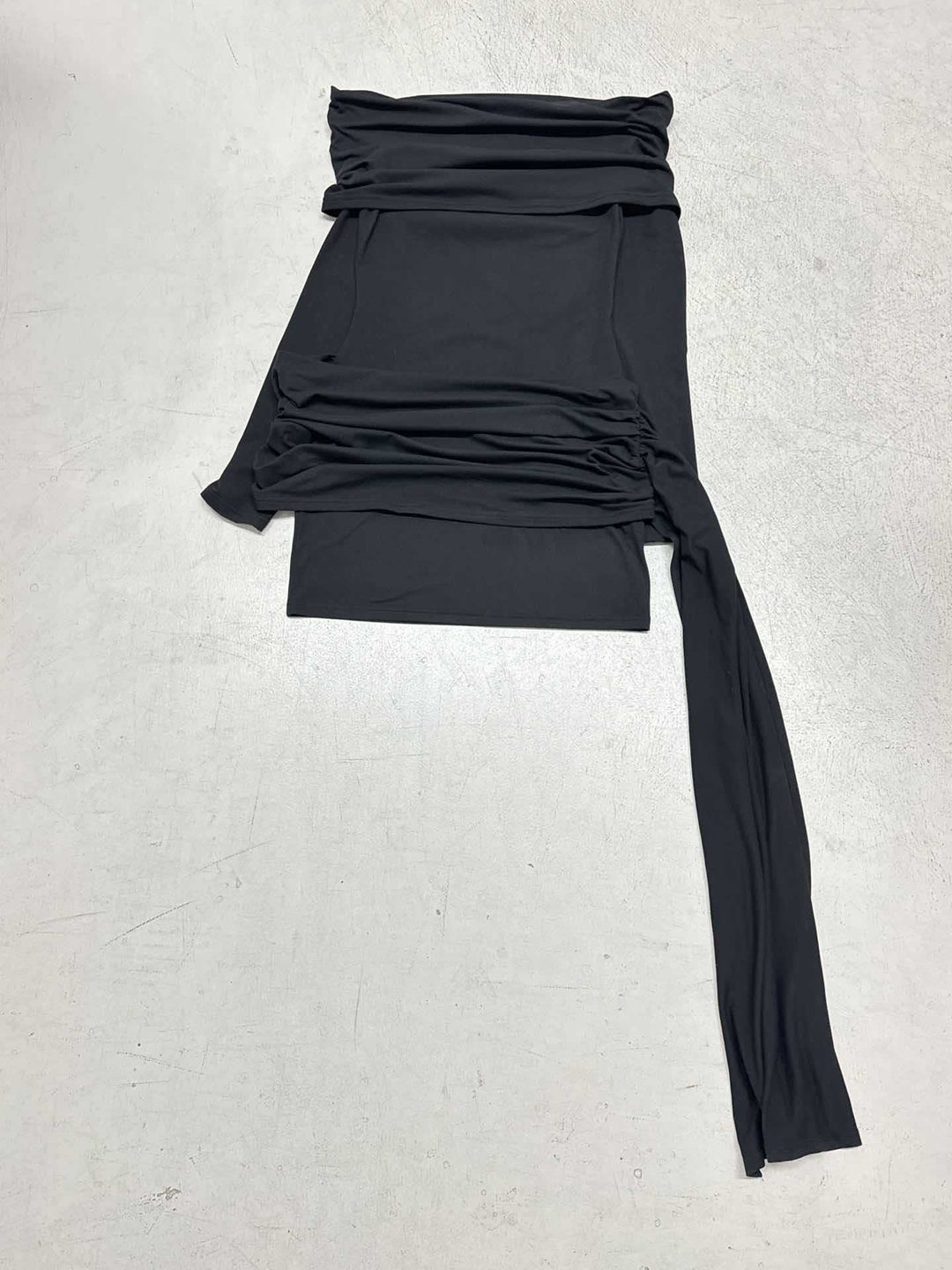 Detaljert bilde av svart volang-lounge-topp for damer. Fremhever de unike ermevolangene og myke teksturen.
