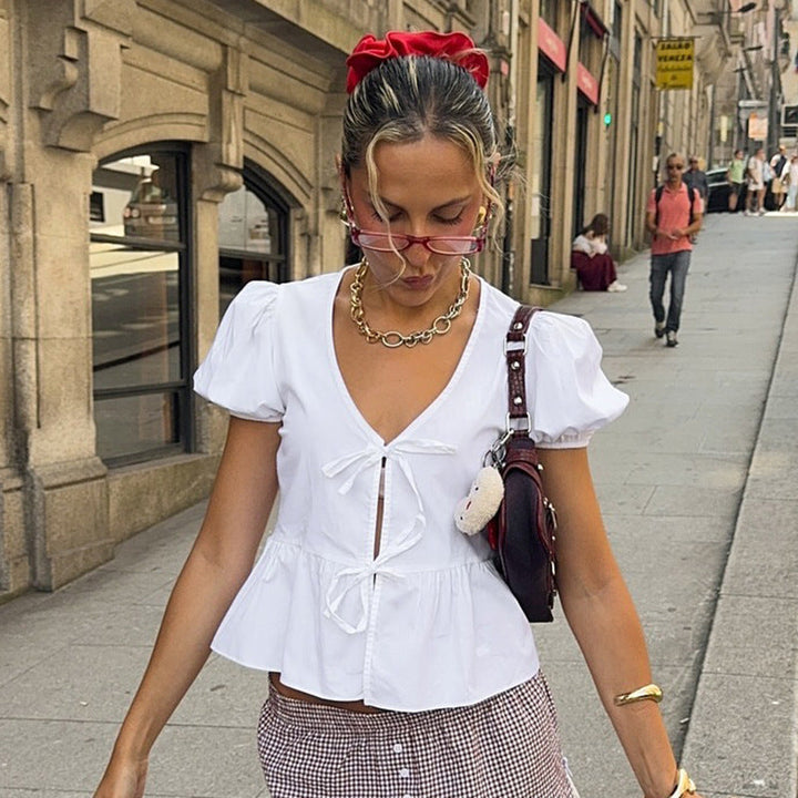 Elegant dame innpakningsbluse med puffermer og peplumkant i tidløs design. Perfekt for fest og hverdag.