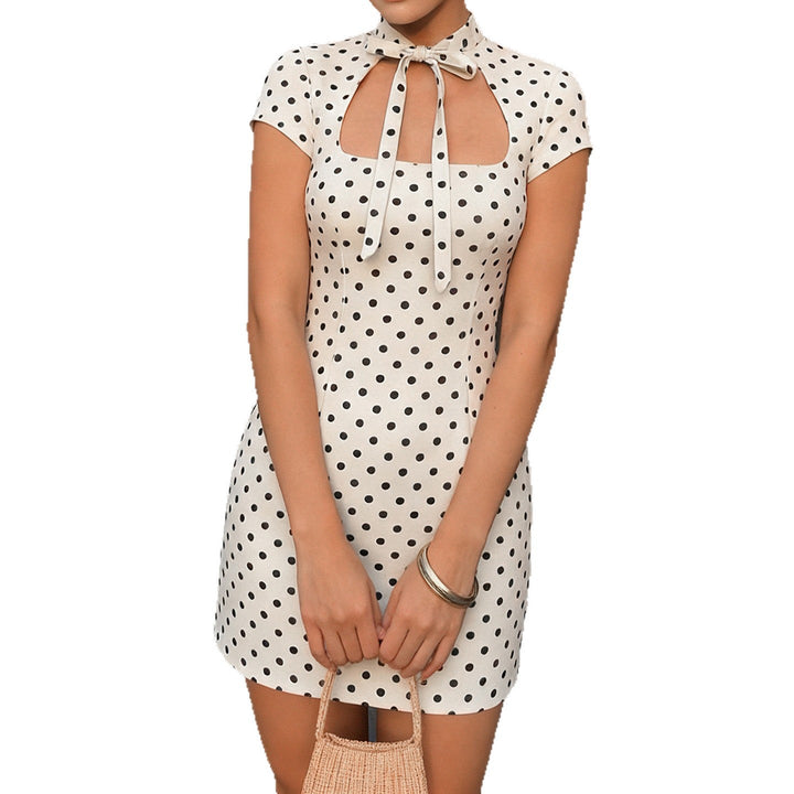 Bakside av hvit polka-dot minikjole med krage, viser elegant snitt. Ideell for fest eller hverdagsbruk.