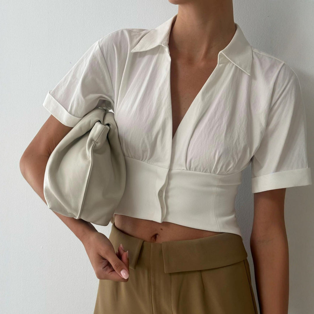Hvit kortermet damebluse med V-hals, perfekt for sommer og vår. Elegant og behagelig hverdagsbluse.
