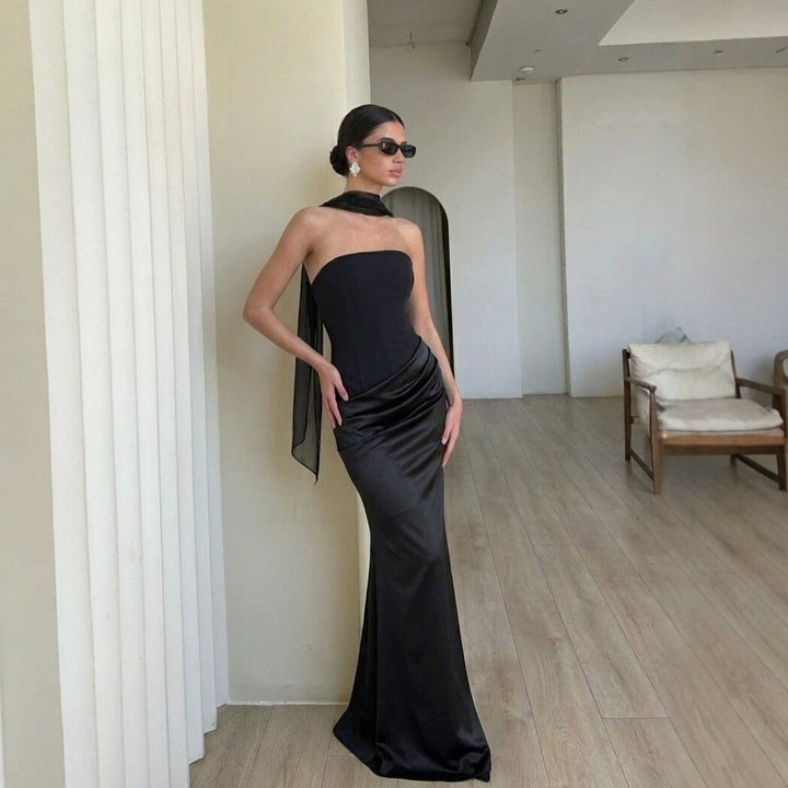 Klassisk cocktailkjole med myk stretch og elegant drapering langs midjen, fremhever feminine former.