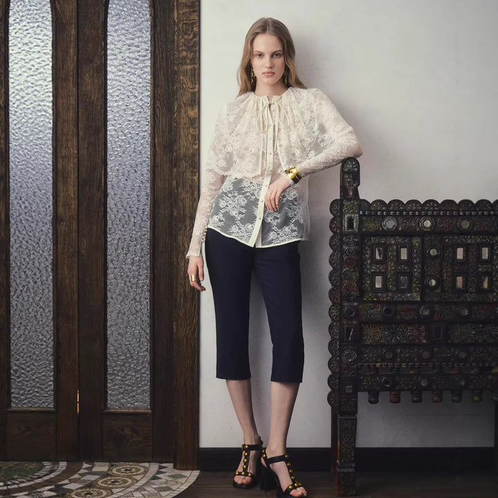 Kvinnebluse med elegante transparente ermer og fin sløyfedetalj, ideell for vår- og sommermote.