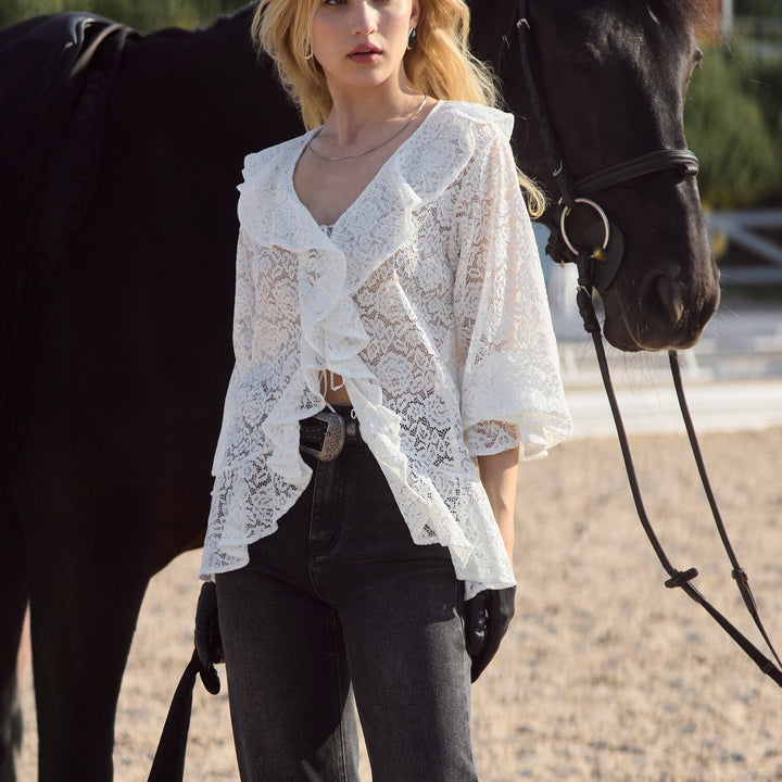 Elegant hvit damebluse med voluminøse volanger, perfekt for vår og sommer. Stilren topp for festantrekk.