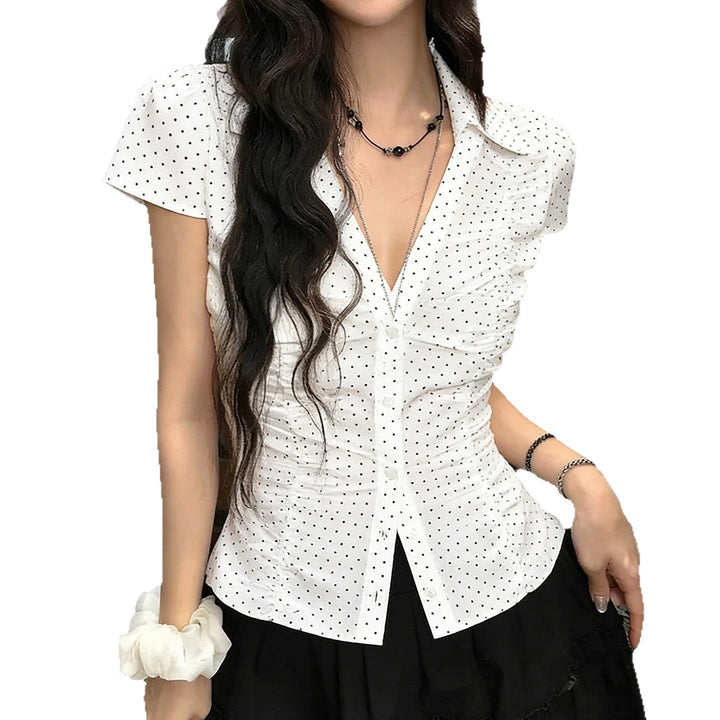 Stilig kortermet bluse for damer med volanger og klassiske prikker. Perfekt for både casual og elegant sommerlook.