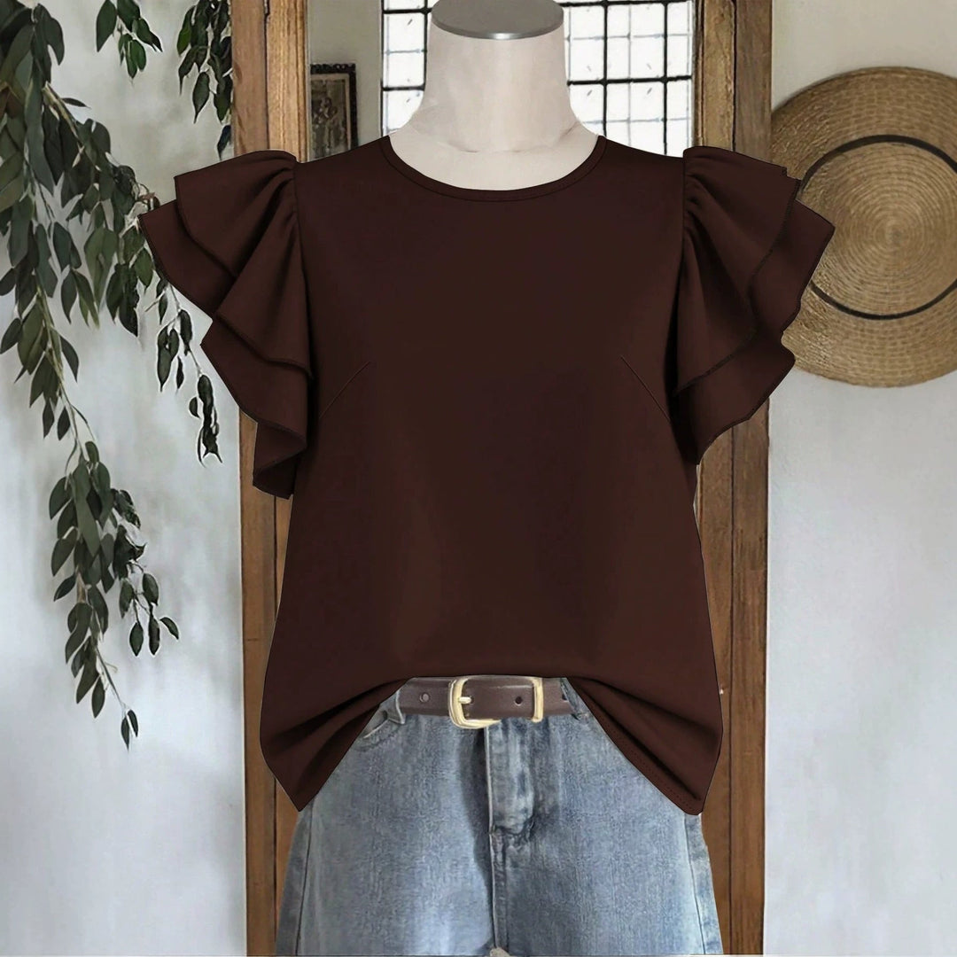 Hvit løs damebluse med stilige volanger. Trendy og behagelig for vår- og sommermote.