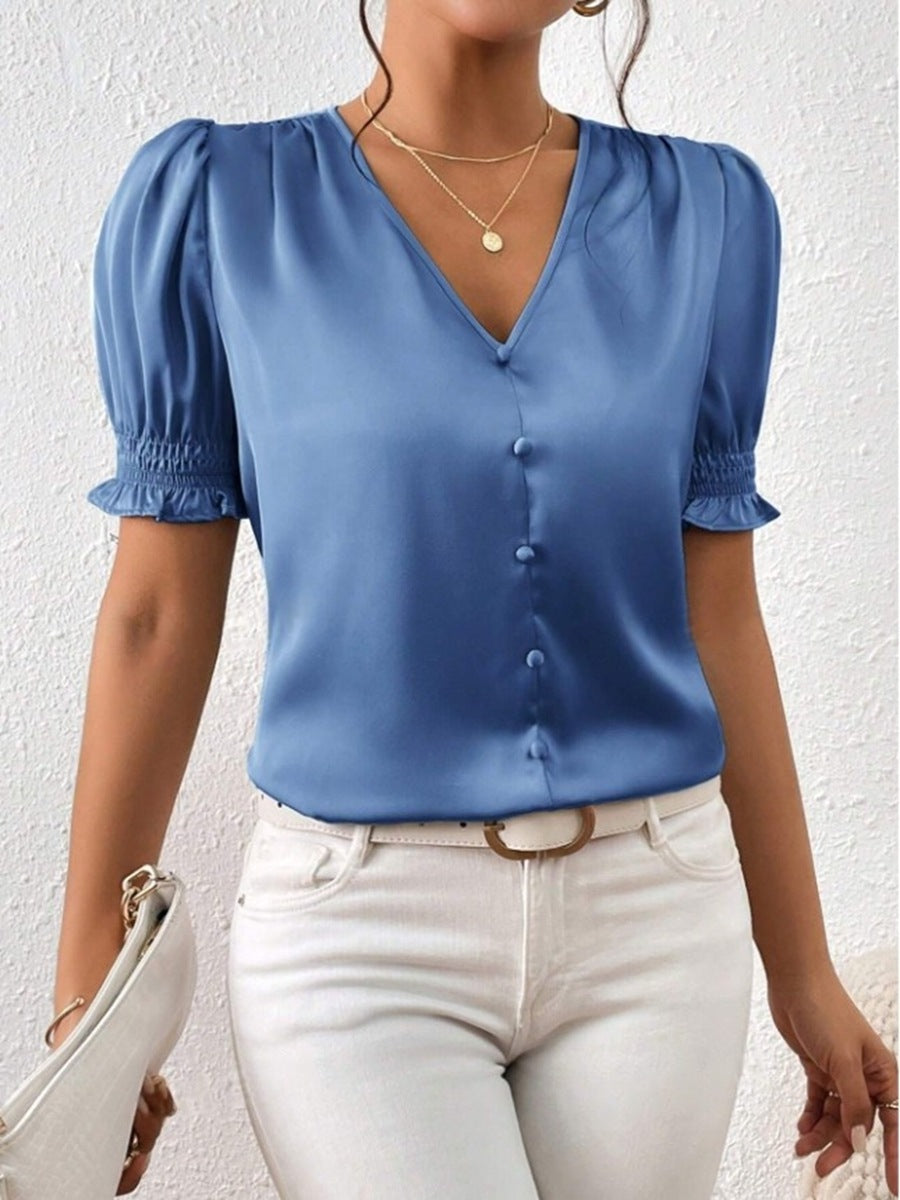 Tidløs damebluse, perfekt for våren, med markerte puffermer og funksjonell knappeliste.