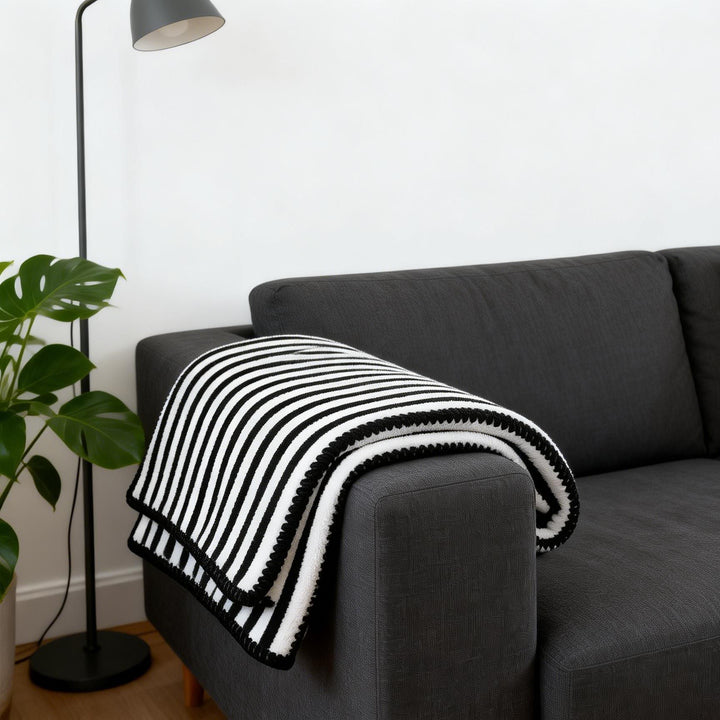 Nærbilde av mykt og varmt fleecepledd med stripedesign. Komfortabelt og koselig for hjemmekos.