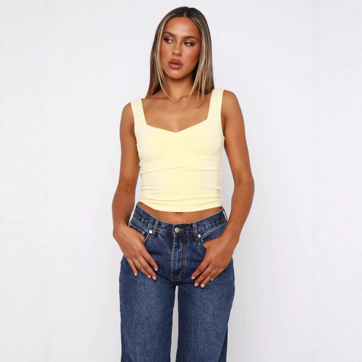 Lys gul figurnær V-hals crop-top til dame med brede stropper. Trendy, komfortabel sommerstil.