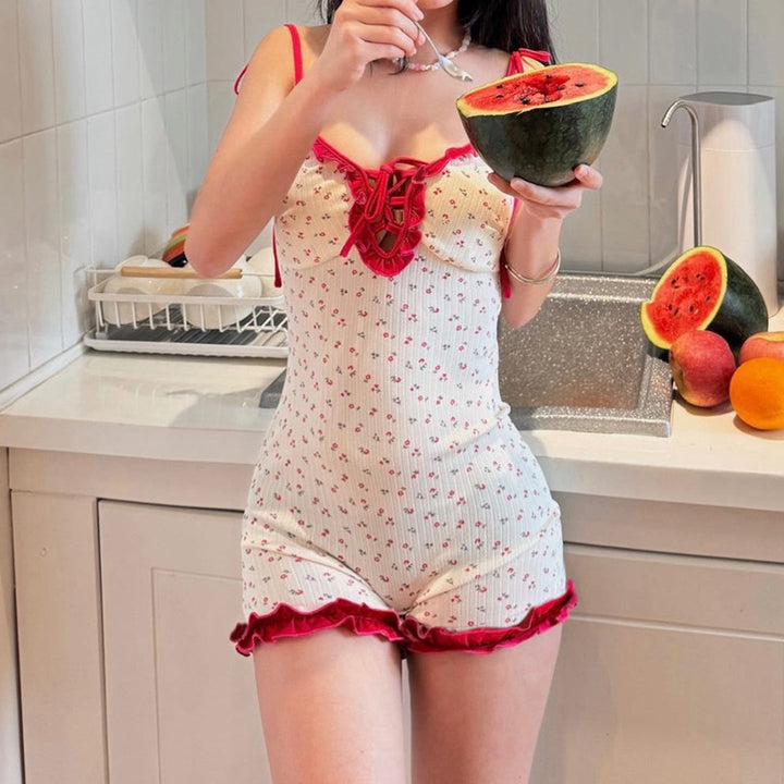 Hvit damejumpsuit med lekent blomstermønster og elegante volangdetaljer for sommerlige anledninger.