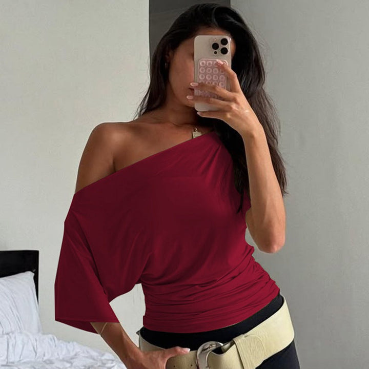 Elegant og stilfull dametopp med asymmetrisk utringning, rynkedetaljer, ideell som festtopp eller vårtopp.