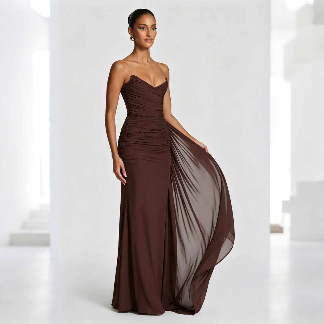 Lang elegant damekjole i brun med asymmetrisk drapering, ideell som kvelds- eller festkjole.