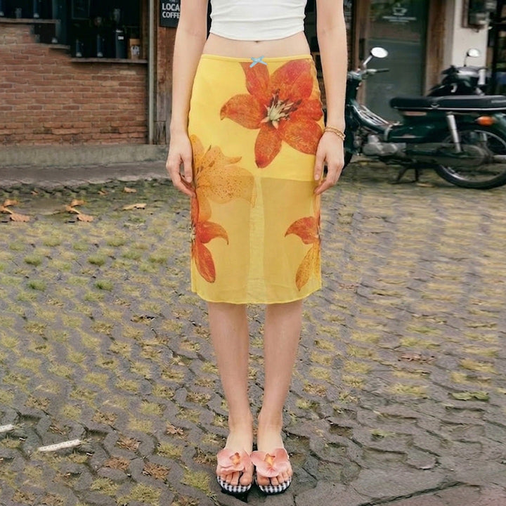 Gult midi skjørt med livlig blomsterprint, A-linje design og behagelig elastisk midje for sommermote.