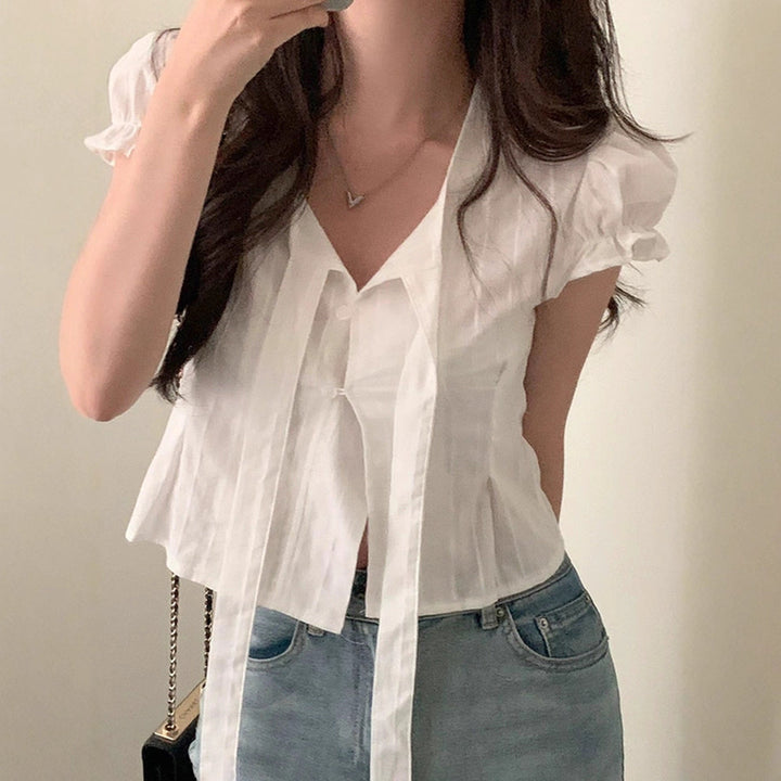 Casual kortermet damebluse i hvitt med knytesnorer og V-hals. Ideell som vår- eller sommerbluse.