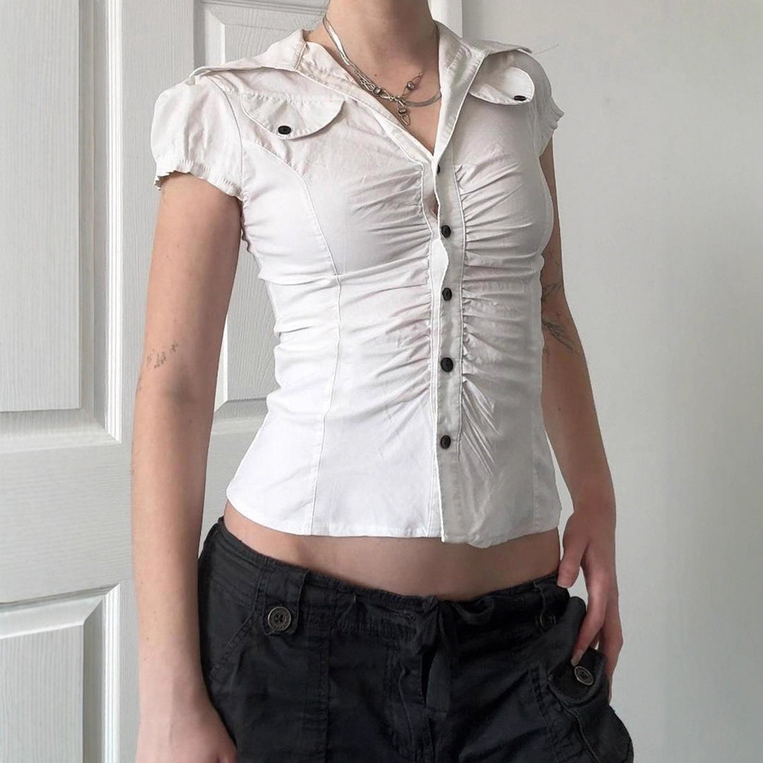 Hvit elegant figurnær damebluse med kortermede volanger, perfekt for en stilig sommerlook.