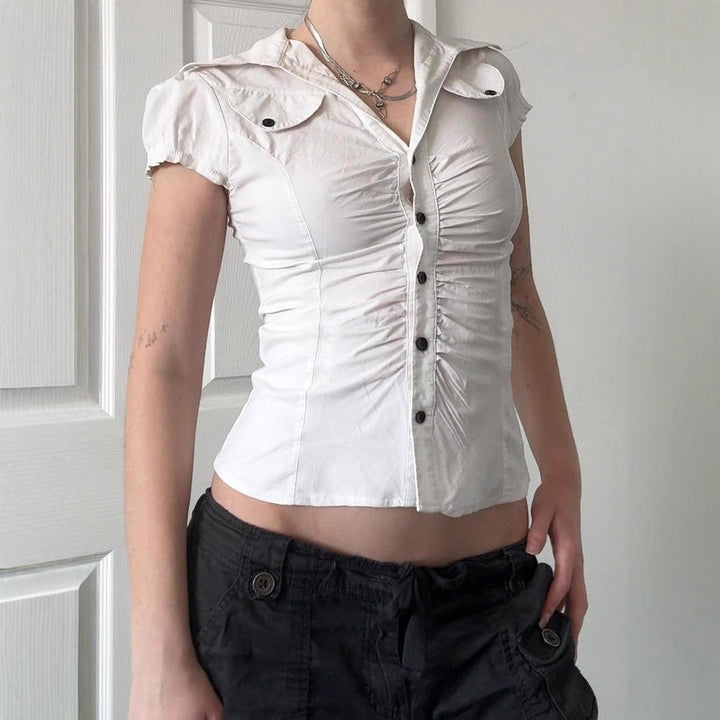 Hvit elegant figurnær damebluse med kortermede volanger, perfekt for en stilig sommerlook.
