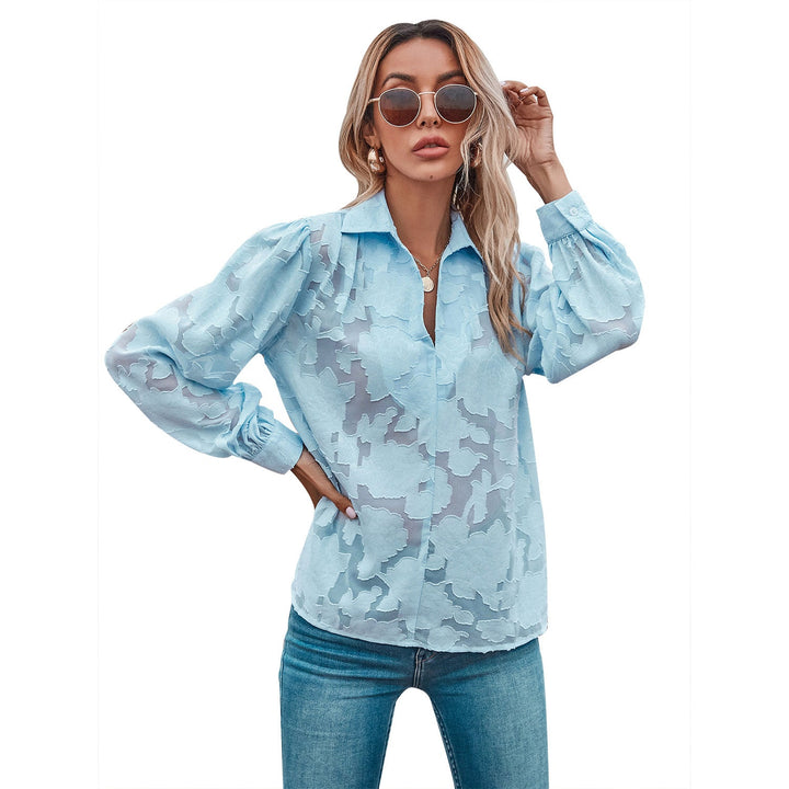 Himmelblå damebluse med blomsterdesign og ballongermer. Elegant V-hals bluse for sommer, fritid og jobb.