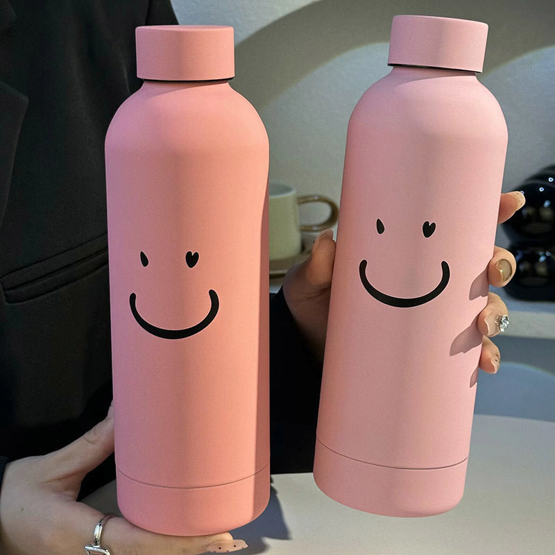 Dame termoflaske i stål med søtt smilefjes, perfekt for varm eller kald drikke på fritidsreiser.