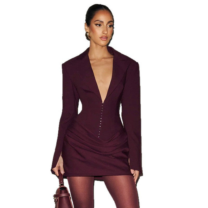 Kvinne iført elegant sort blazer-minikjole med dyp V-hals, stilfull og moderne festkjole.