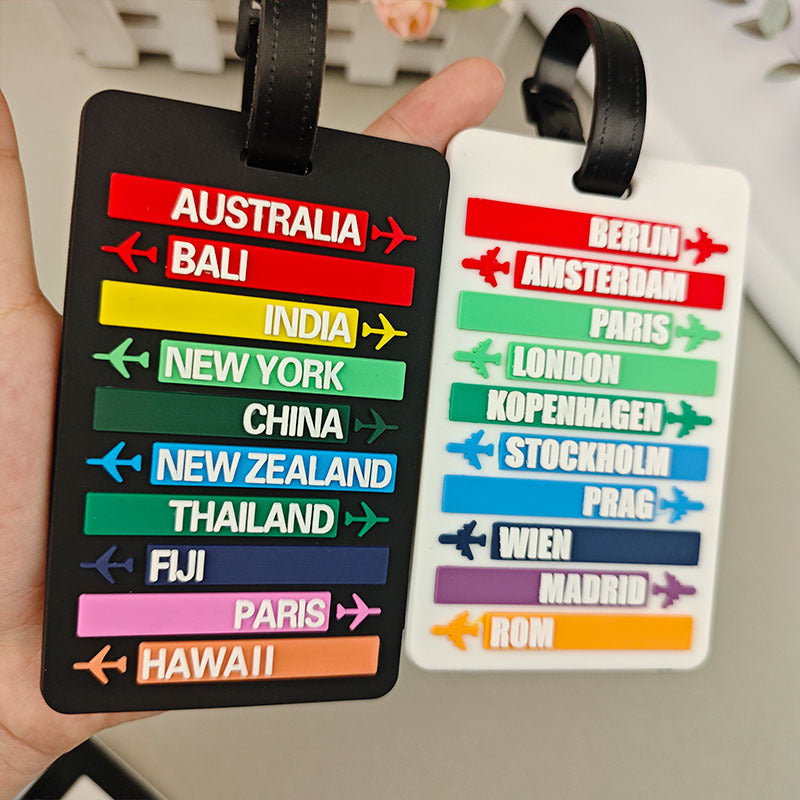 Detalj av plast bagasjetag med navn på reisemål som New York, Paris og London.