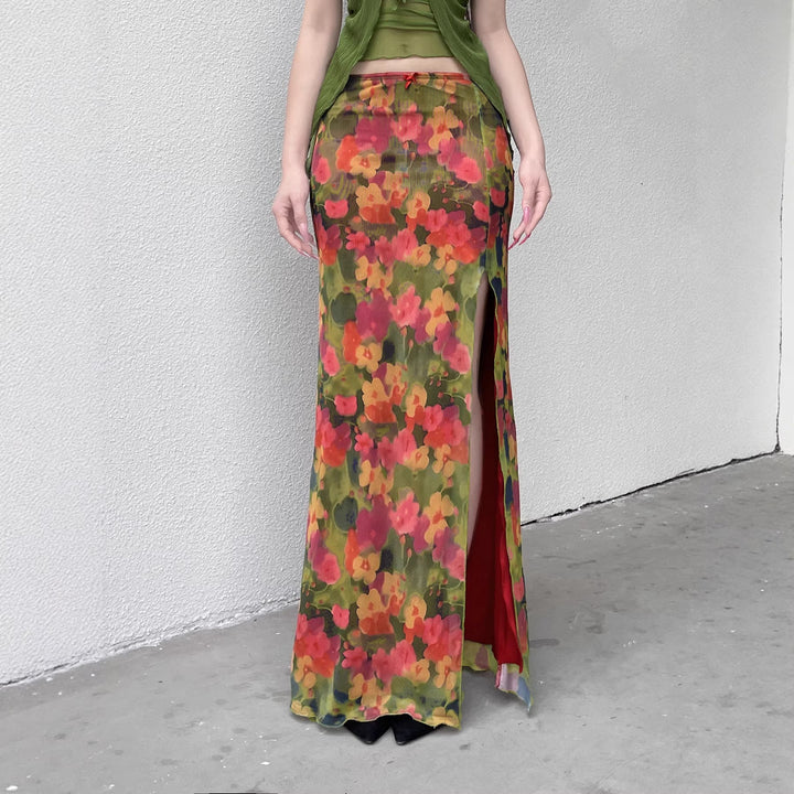 Elegant dame maxiskjørt med fargerikt blomsterprint og sidesplitt, perfekt for sommerfest og strand.