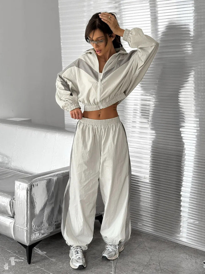 Stilfull dametreningsdress i fargekoordinert design. Komfortabelt matchende sett med jakke og bukser for fritid.