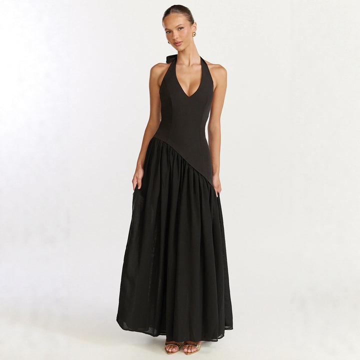 Elegant dame maxikjole med V-hals og unikt asymmetrisk skjørt. Perfekt for fest og sommer.