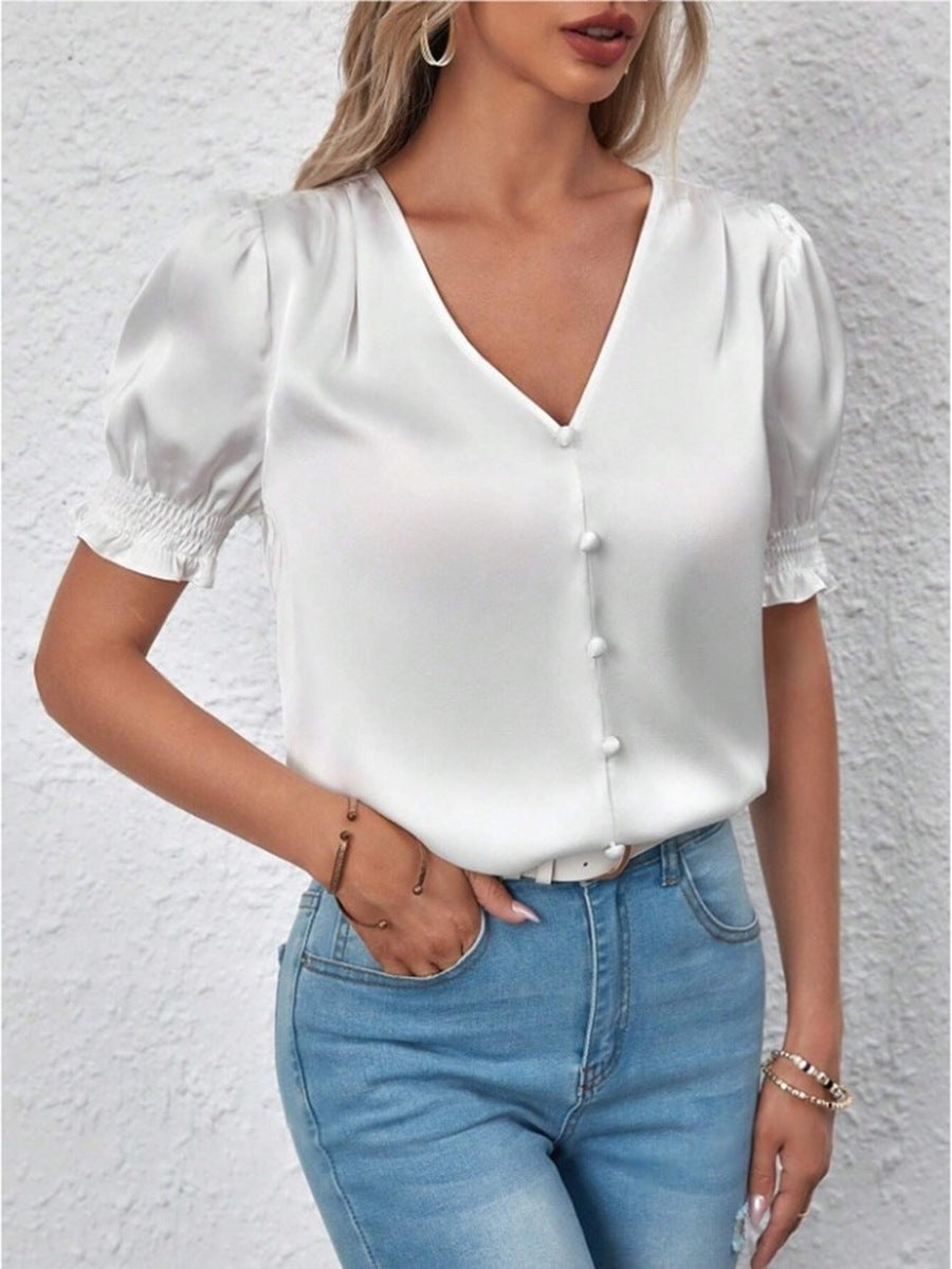 Moderne damebluse i lett stoff, med elegante puffermer og en chic knappeliste. Vår/sommer.