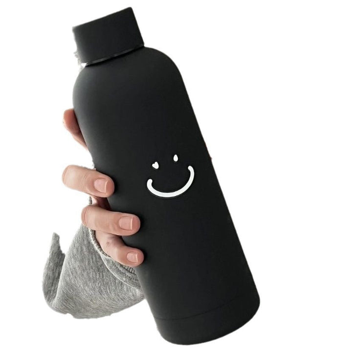 Svart 500ml drikkeflaske i rustfritt stål med livlig smiley-trykk. Perfekt isolert dameflaske.