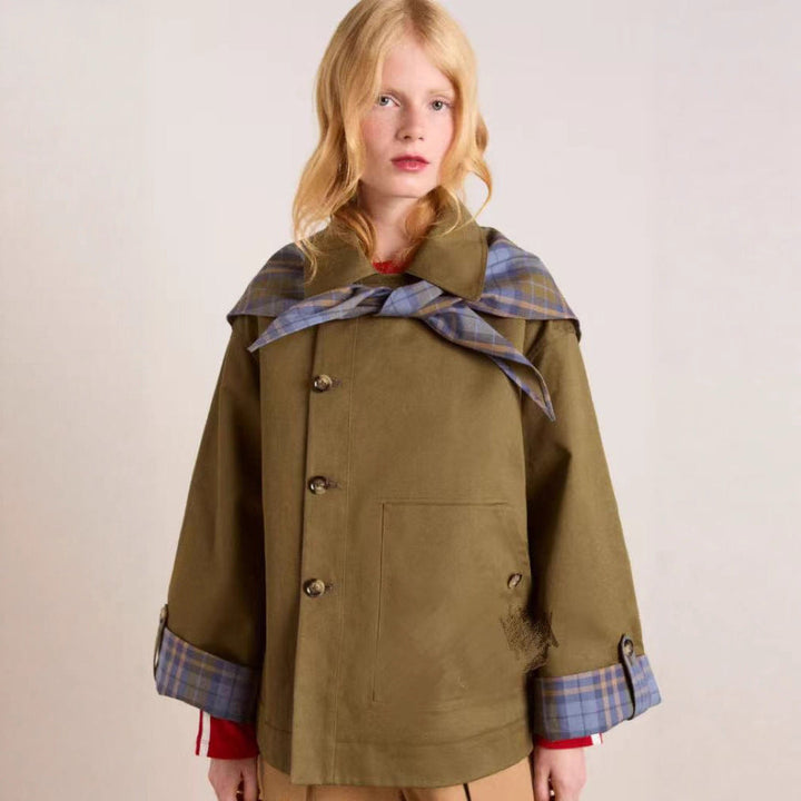 Kvinnelig brun trenchcoat med klassisk krage, belte og praktiske lommer. Perfekt yttertøy for vår og høst.