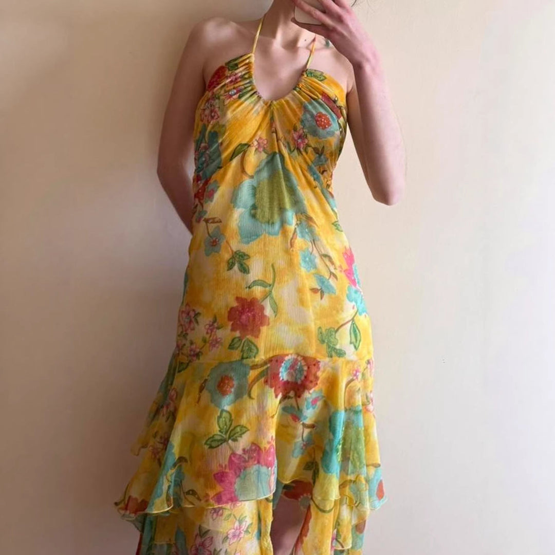 Gul maxikjole med flytende blomsterdesign og tynne spaghetti-stropper. Elegant sommerkjole.