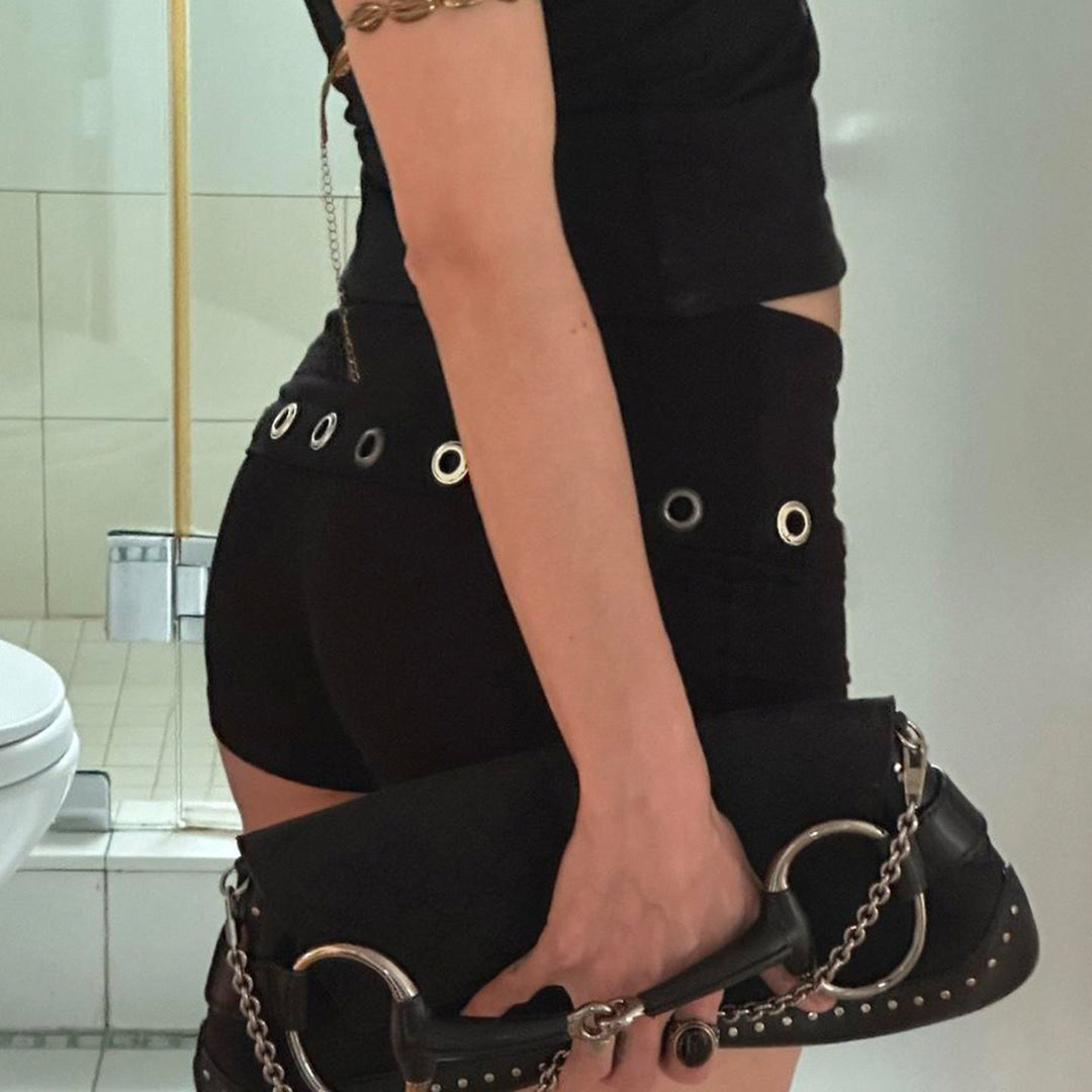 Sporty badebukser i svart til dame, med elegante metallringer på sidene. Perfekt for aktive dager på stranden.