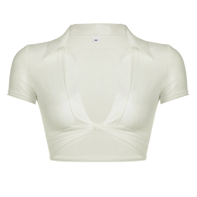Hvit cropped damebluse med dyp V-hals og knutedetalj. Elegant og trendy sommerbluse for enhver anledning.